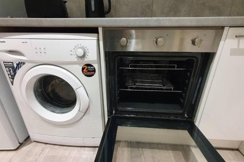 uma máquina de lavar e secar roupa numa cozinha ao lado de uma máquina de lavar roupa em Studio flat in lovely Alexandra Palace London em Londres