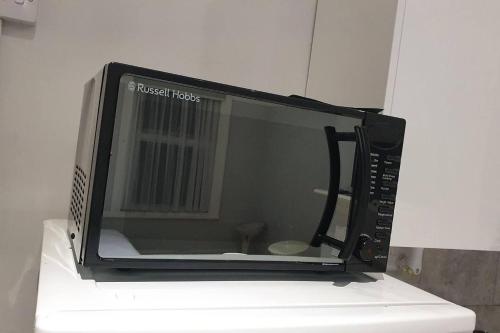 a microwave oven sitting on top of a counter at Studio flat in lovely Alexandra Palace London in London