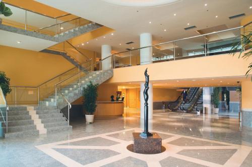 a lobby with stairs and a statue in the middle at Windsor Barra Hotel in Rio de Janeiro