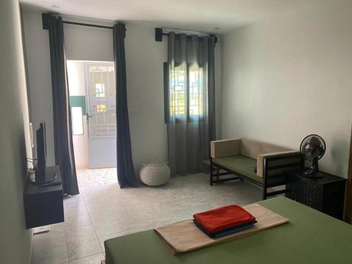sala de estar con mesa y sofá en Studio neuf independant dans villa en Ouoran