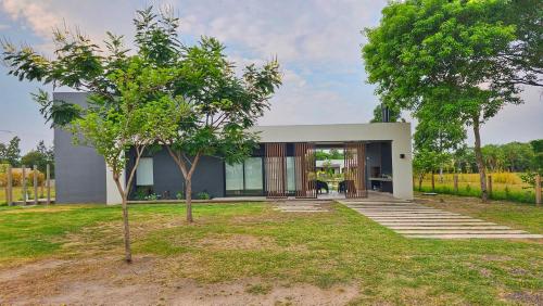 Casa moderna con puertas de cristal y árboles en Guyra, Casas Boutique en Corrientes