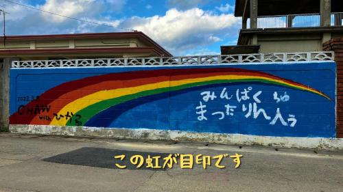 Mural tęczy na ścianie w obiekcie 民泊まったりん人 w mieście Janadō