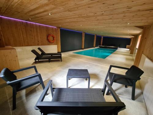 a swimming pool in a room with chairs and tables at Birch Cottage in Hope