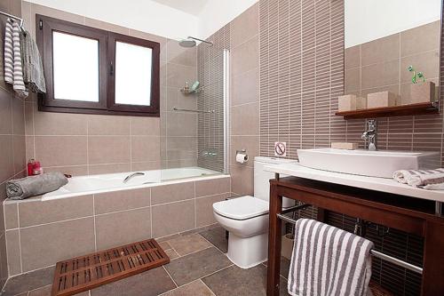 a bathroom with a tub and a toilet and a sink at Villa Arcadia, Kallepia in Paphos