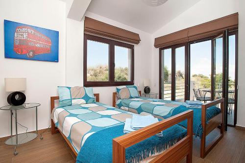 dwa łóżka w pokoju z dwoma oknami w obiekcie Villa Arcadia, Kallepia w Pafos