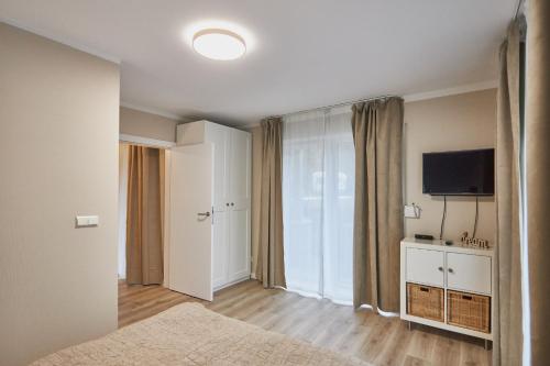 um quarto com uma cama e uma televisão de ecrã plano em Apartamenty Świnoujście - Rezydencja Bursztyn em Świnoujście