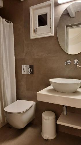 a bathroom with a sink and a toilet and a mirror at Casa Bianca in Ornos