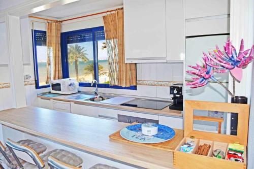 a kitchen with a counter with a sink and a table at ShoreHouse Apartamento Primera linea Playa Honda in Playa Honda