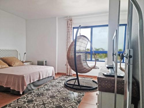 a room with a bed and a desk with a fan at ShoreHouse Apartamento Primera linea Playa Honda in Playa Honda