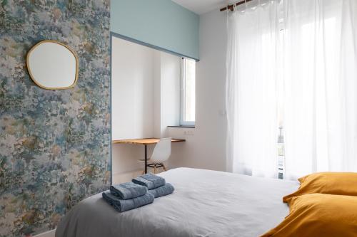 um quarto com uma cama com toalhas azuis em Appartement spacieux em Quimper