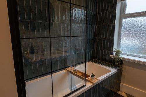 a bathroom with a bath tub and a window at The Willows in Newton-le-Willows