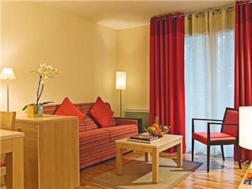 a living room with a couch and red curtains at La Villa Du Lac- 3 rooms for 6 people in Divonne-les-Bains