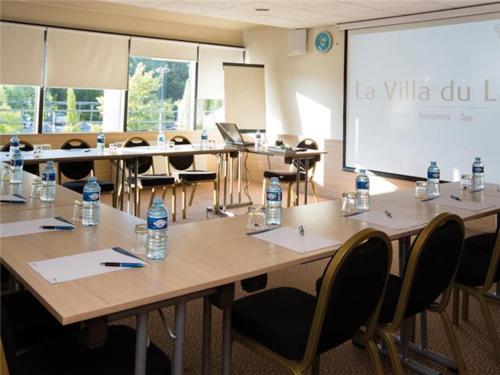a classroom with tables and chairs and a large screen at La Villa Du Lac- 3 rooms for 6 people in Divonne-les-Bains