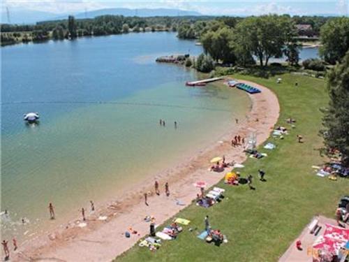 a group of people on a beach near a body of water at La Villa Du Lac- 3 rooms for 6 people in Divonne-les-Bains