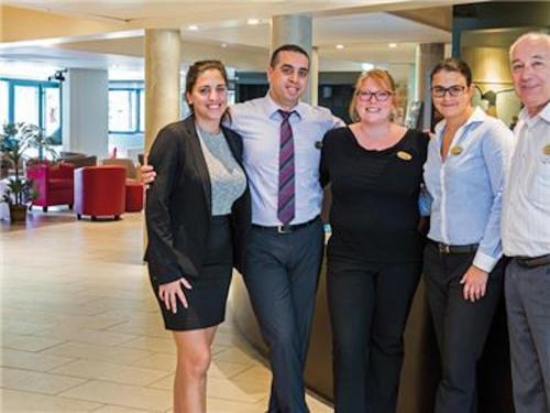 a group of people posing for a picture in a lobby at La Villa Du Lac- 3 rooms for 6 people in Divonne-les-Bains