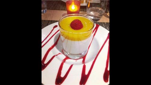 a drink with a raspberry on a plate with sauce at La Villa Du Lac- 3 rooms for 6 people in Divonne-les-Bains