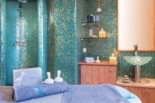 a bathroom with a shower and a bed and candles at La Villa Du Lac- 3 rooms for 6 people in Divonne-les-Bains