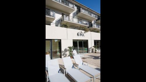 a group of white chairs sitting outside of a building at La Villa Du Lac- 3 rooms for 6 people in Divonne-les-Bains