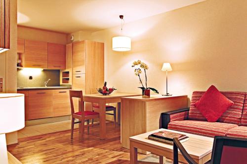 a living room and kitchen with a couch and a table at La Villa Du Lac- 3 rooms for 6 people in Divonne-les-Bains