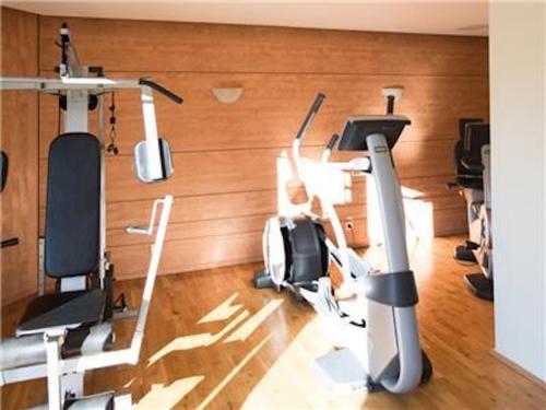 a person in a gym with several tread machines at La Villa Du Lac- 3 rooms for 6 people in Divonne-les-Bains