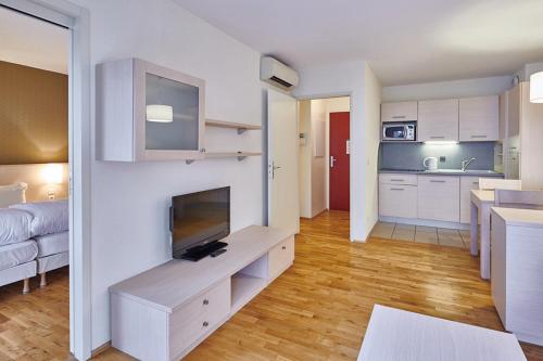 a kitchen and a living room with a television in a room at La Villa Du Lac- 3 rooms for 6 people in Divonne-les-Bains