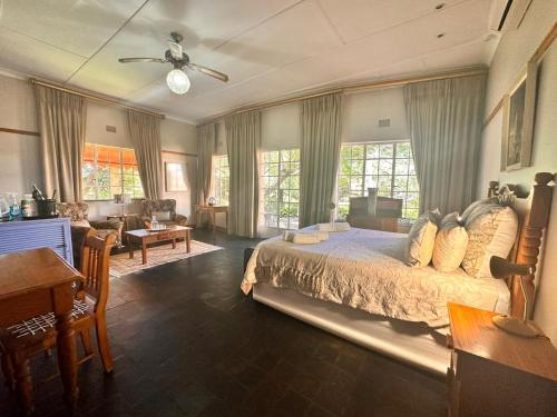 a bedroom with a bed and a living room at Farm stay at Saffron Cottage on Haldon Estate in Bloemfontein