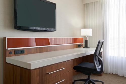 a room with a desk with a tv and a chair at Delta Hotels by Marriott Toronto Airport & Conference Centre in Toronto
