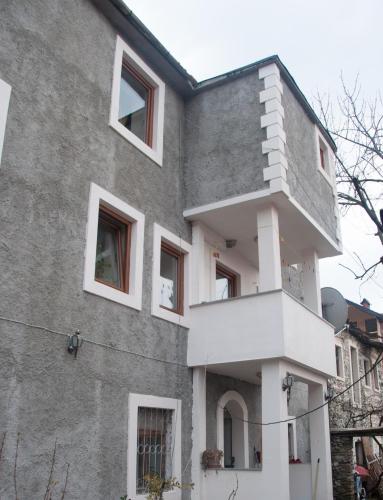 a facade of a building with white windows at Aste Guesthouse in Tropojë
