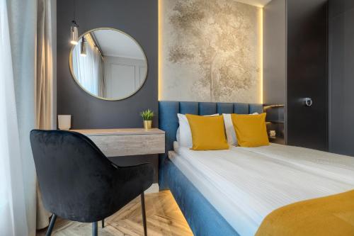 um quarto com uma cama com almofadas amarelas e um espelho em Margi Whisky Apartament LUX AIRCON em Szczecin