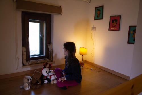 a young girl sitting on the floor with stuffed animals at Guest Art Campitello Matese in San Massimo