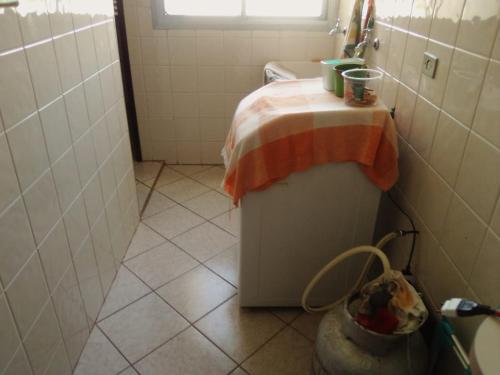 uma pequena casa de banho com um chuveiro e uma toalha em cima em AP DANTAS em Caraguatatuba