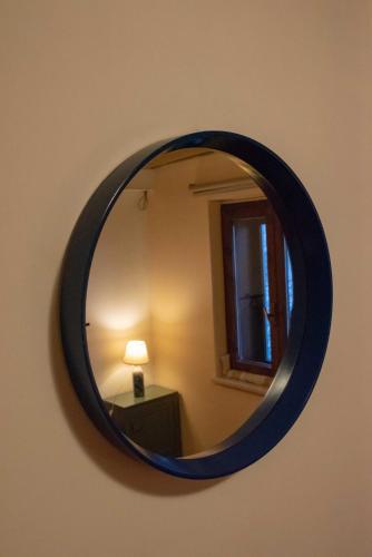 a round mirror on a wall with a lamp in a room at Guest Art Campitello Matese in San Massimo