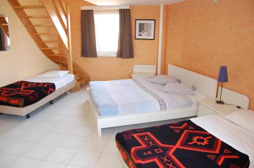a bedroom with two beds and a staircase at Westhoek Apartments in De Panne