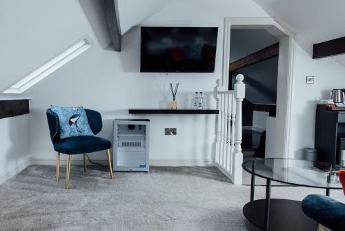 紹斯波特的住宿－Arthur's Bar & Accommodation，客厅配有蓝色椅子和桌子