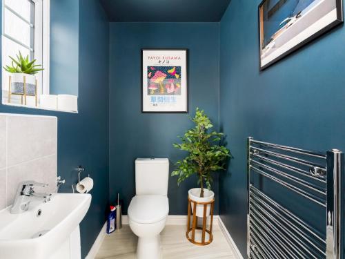 La salle de bains est pourvue de toilettes blanches et d'un mur bleu. dans l'établissement Pass the Keys 8 Foundry Walk Stylish House with Parking, à Birmingham