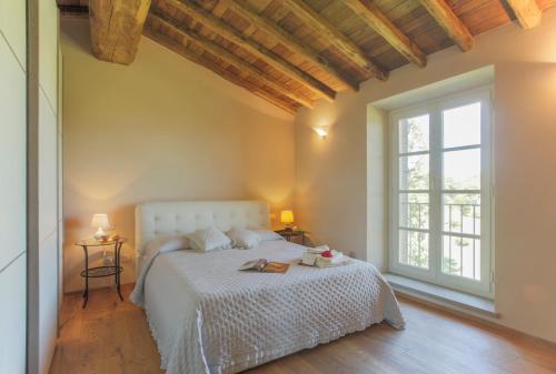 una camera con un letto bianco e una grande finestra di SUNRISE a Capannori