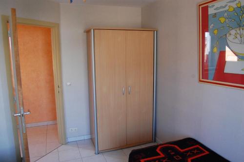 a room with a wooden cabinet in the corner at Westhoek Apartments in De Panne