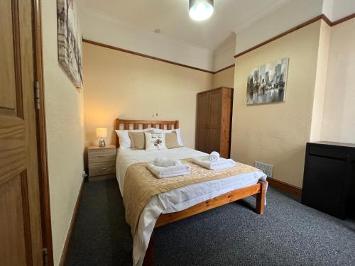 um quarto com uma cama com duas toalhas em Tŷ Summerfield by Dream Short Stays em Cardiff