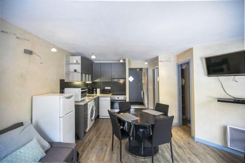 a kitchen and living room with a table and chairs at L'Esquiròu - Proche pistes pour 6 in Barèges