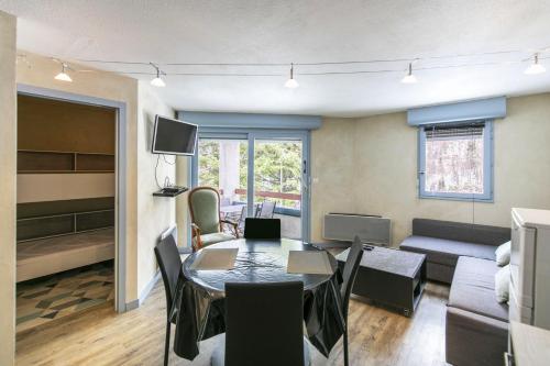 a living room with a table and a couch at L'Esquiròu - Proche pistes pour 6 in Barèges