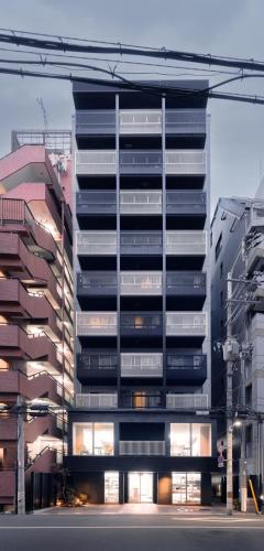 a tall building with many windows in a city at Apartment Hotel 11 Namba in Osaka