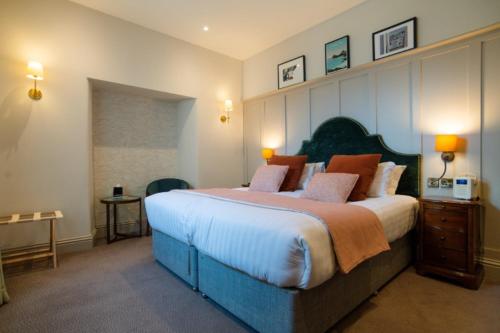 a large bedroom with a large bed with orange pillows at Mullion Cove Hotel & Spa in Mullion