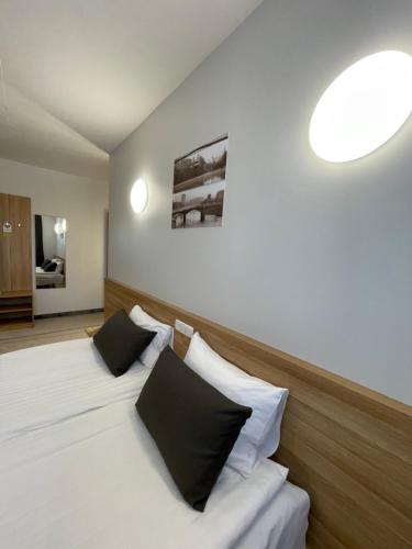 a bedroom with two beds with black and white pillows at Green Vilnius Hotel in Vilnius