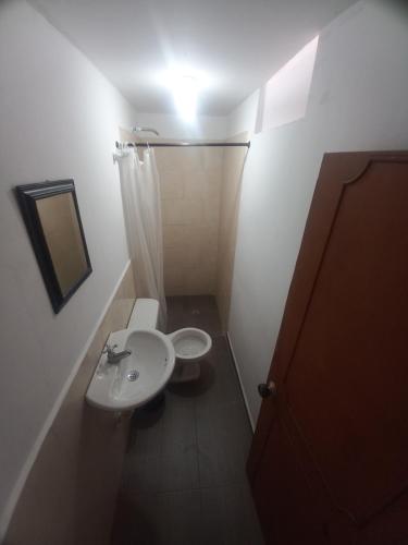 a small bathroom with a toilet and a sink at villa de las palmas in Palmira