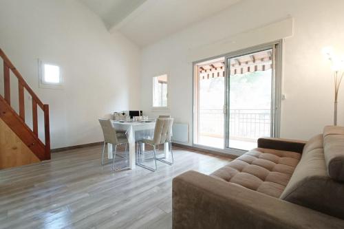 un salon avec un canapé et une table avec des chaises dans l'établissement Spacious sea view apart at 50m from the beach, à Bandol