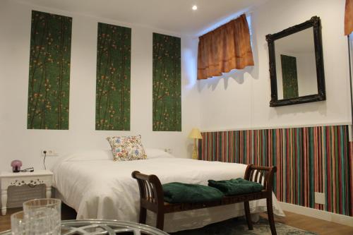 a bedroom with a bed and a mirror and a chair at finca dos Mares in Ferrol