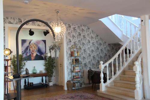 a room with a staircase with a painting of a woman at finca dos Mares in Ferrol