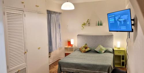 1 dormitorio con 1 cama y TV de pantalla plana en la pared en Bookingrent Palermo1 en Buenos Aires