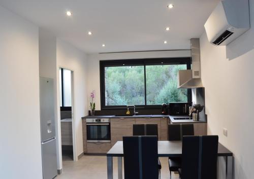 une cuisine avec une table et une grande fenêtre dans l'établissement N5 Maison T2 climatisé, à Ajaccio