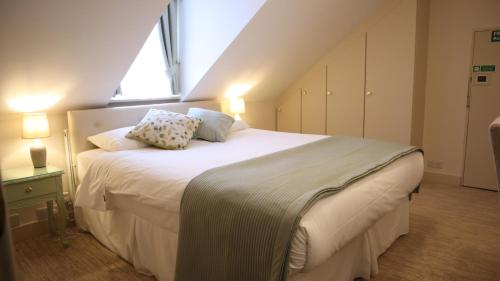 a bedroom with a large bed with two pillows on it at Centennial Hotel in Cambridge